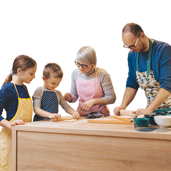 middle aged couple making pizza at home with their young kids